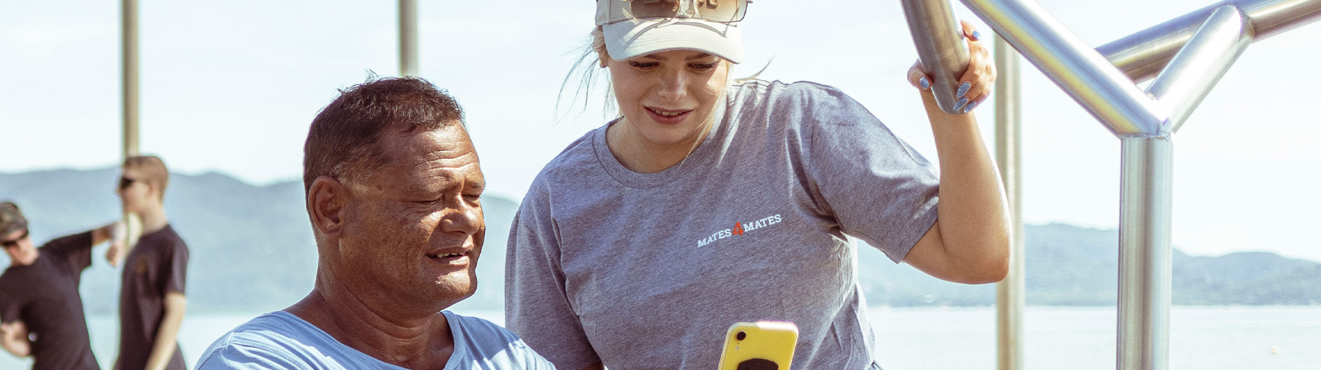Two people standing together looking at a mobile phone screen.