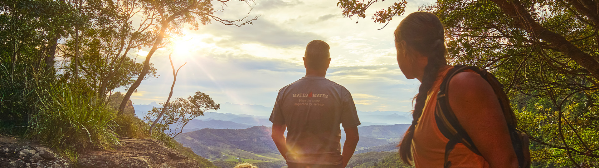A group taking a break from a hike at the top of a waterfall.