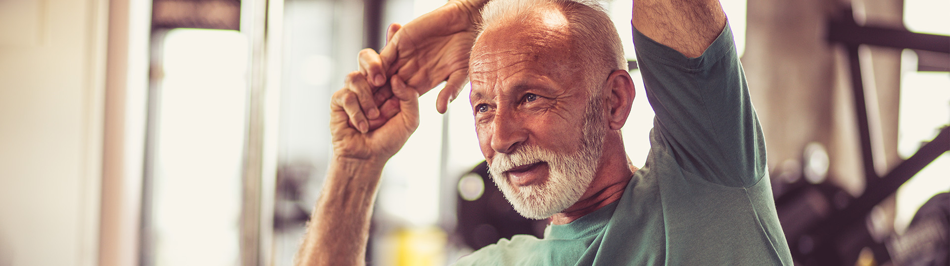 Older man doing stretches in a gym