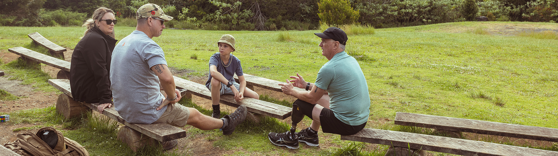 Group sitting together on bench seats in an outdoor settings talking.