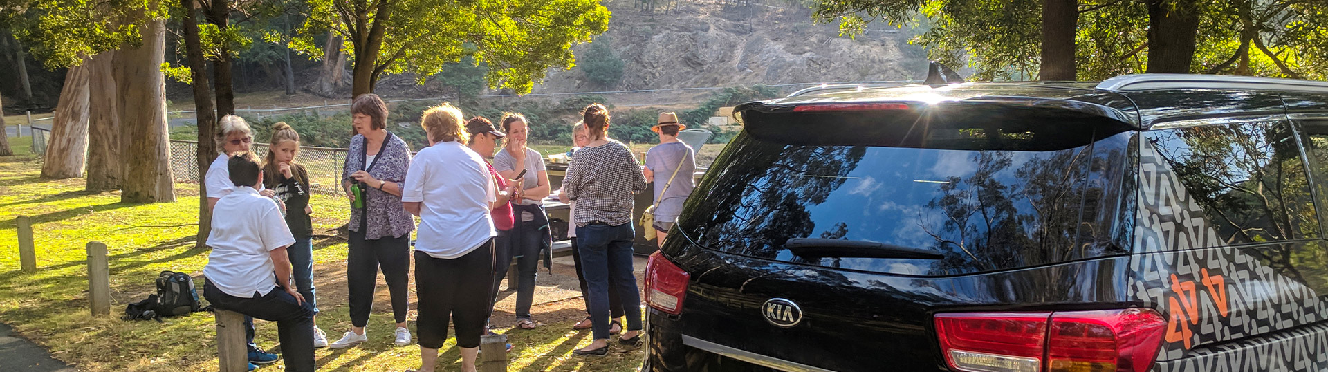 A group standing outside next to a Mates4Mates van at a social connection activity.